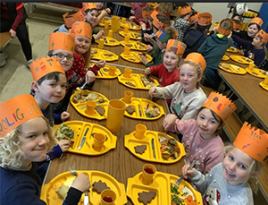 pupils wearing christmas hats and enjoying their christmas dinner