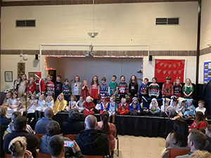 pupils on a stage dressed in christmas outfits
