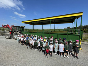 Young children in Foel Farm in front of a green tractor
